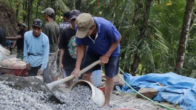 Sejak pagi, Rido tampak tak henti mengayunkan cangkul untuk meratakan hamparan batu split yang menjadi lapisan dasar jalan rabat beton. Bersama personel Satgas TMMD, ia bekerja penuh semangat demi mempercepat pembangunan akses jalan yang telah lama dinantikan masyarakat, Senin (20/7/2026).