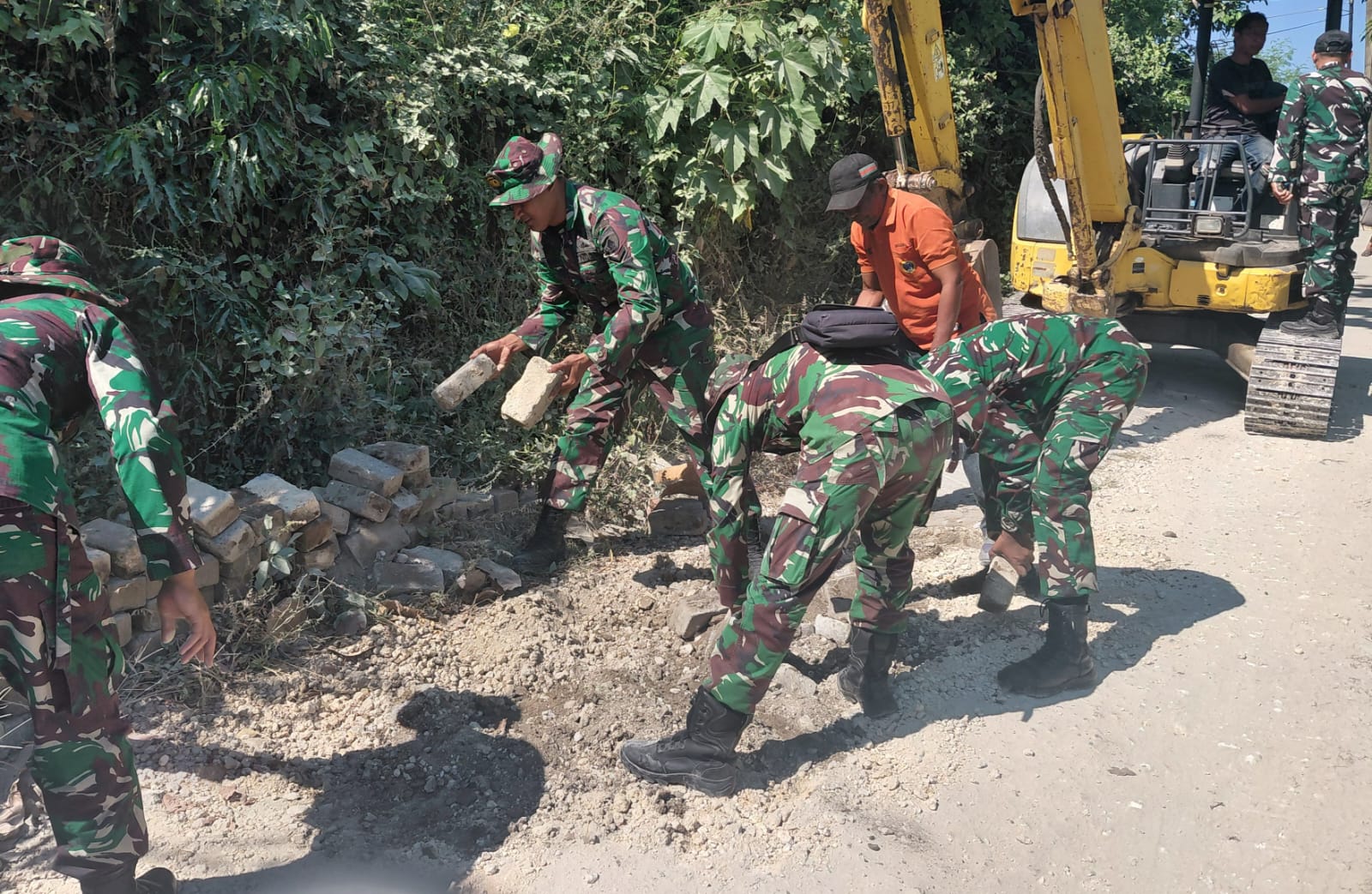 Personel Satgas TMMD ke-129 Kodim 0813 Bojonegoro bersama warga mulai membongkar paving lama sebagai langkah awal pembangunan jalan cor beton yang akan meningkatkan akses transportasi di wilayah tersebut.