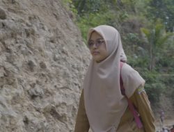 Eni Lestari, guru SD Negeri 6 Gumelem Kulon, saat menyaksikan proses pembangunan jalan rabat beton sepanjang 737 meter dengan lebar 2,5 meter dan ketebalan 15 sentimeter di Dusun Kunir RT 01/RW 09, Selasa (28/7/2026).