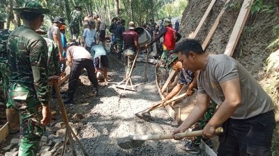 Personel TNI, Polri, dan warga bahu-membahu melanjutkan pembangunan jalan rabat beton dalam program TMMD Reguler ke-129 Kodim 0704/Banjarnegara.