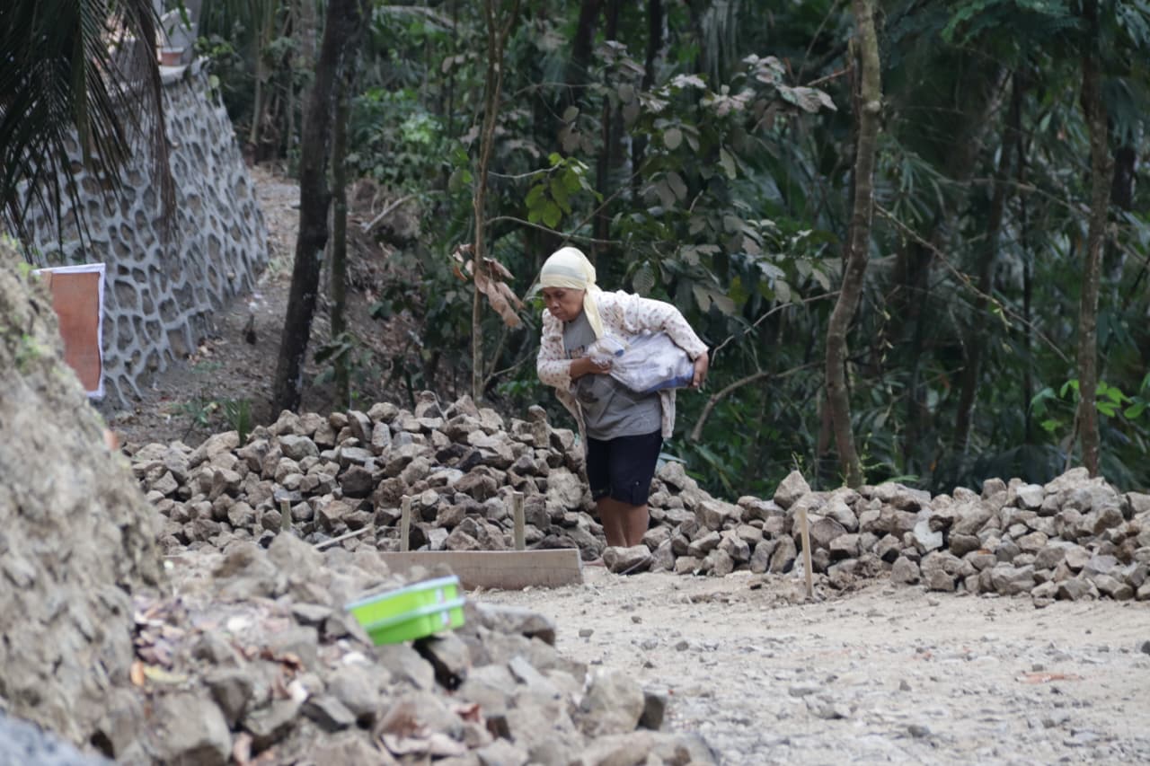 saat membantu melangsir batu kecil menggunakan karung dalam kegiatan TMMD Reguler ke-129 Tahun Anggaran 2026 Kodim 0704/Banjarnegara, Jumat (31/7/2026).