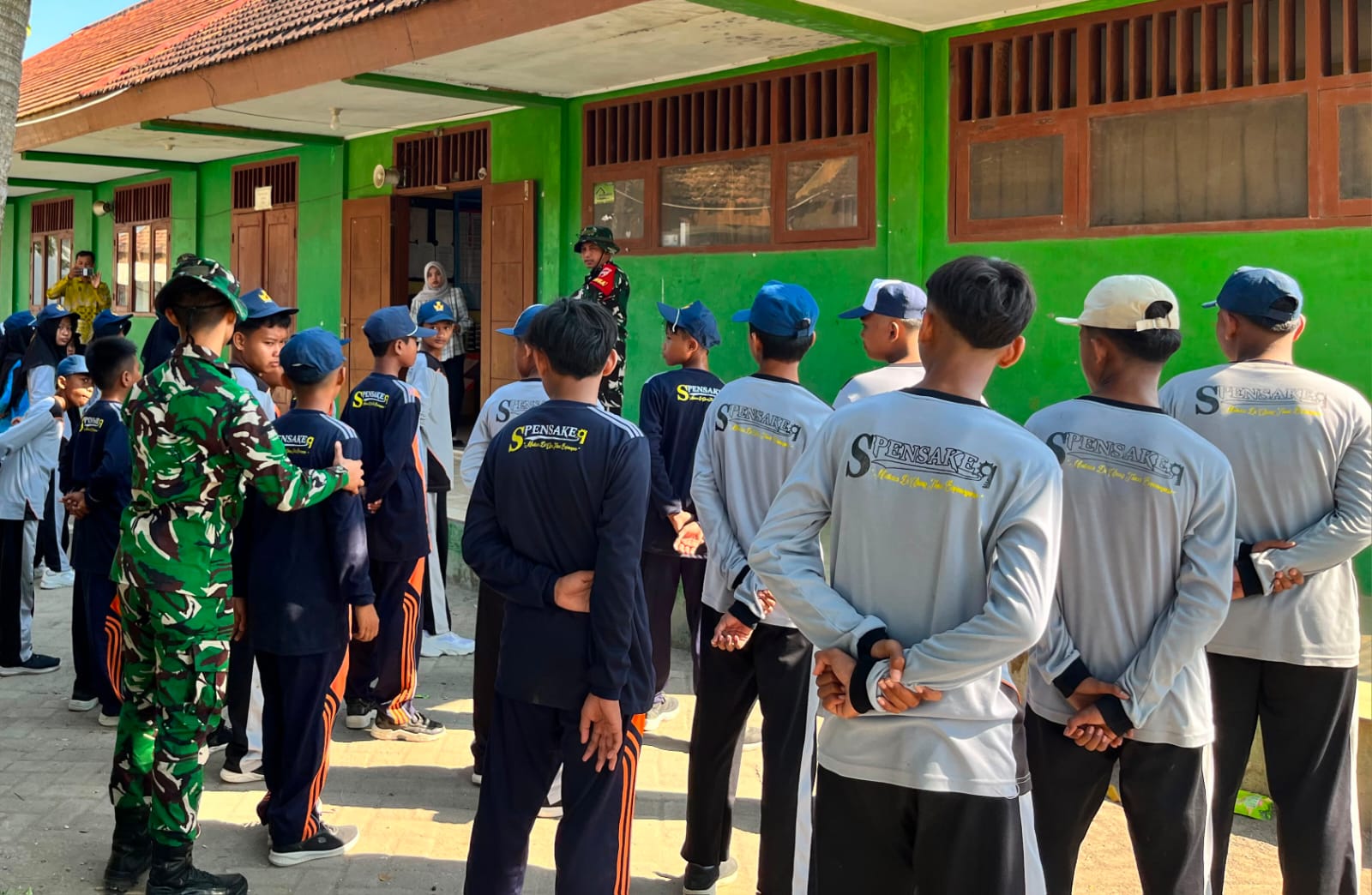 Melalui kegiatan nonfisik, personel Satgas TMMD Kodim 0813 Bojonegoro memberikan pelatihan Peraturan Baris Berbaris (PBB) kepada siswa SMP Negeri Satu Atap Kesongo, Jumat (17/7/2026).