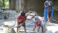 Di tengah kesibukan pembangunan plat beton, seorang warga lanjut usia, Tukijo (65), menunjukkan dedikasi luar biasa dengan turut mengaduk campuran semen dan pasir bersama personel Satgas TMMD, Selasa (21/07/2026).
