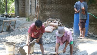 Di tengah kesibukan pembangunan plat beton, seorang warga lanjut usia, Tukijo (65), menunjukkan dedikasi luar biasa dengan turut mengaduk campuran semen dan pasir bersama personel Satgas TMMD, Selasa (21/07/2026).