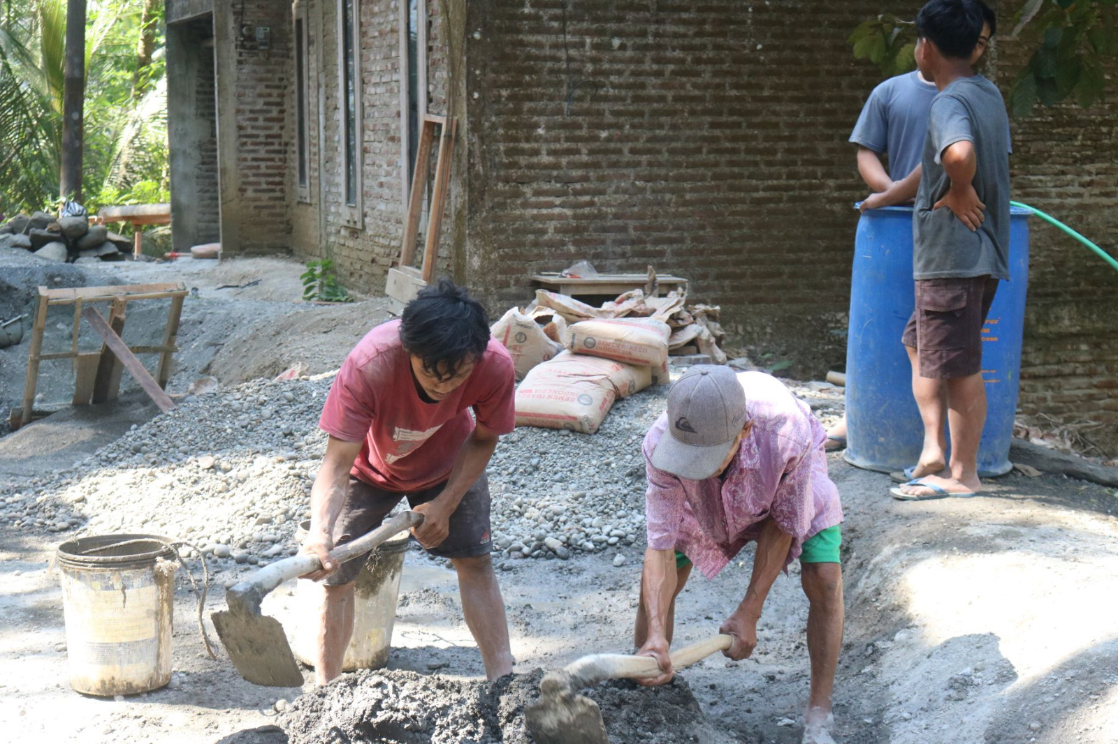 Di tengah kesibukan pembangunan plat beton, seorang warga lanjut usia, Tukijo (65), menunjukkan dedikasi luar biasa dengan turut mengaduk campuran semen dan pasir bersama personel Satgas TMMD, Selasa (21/07/2026).