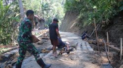 Di Dusun Kunir RT 01/RW 09, Desa Gumelem Kulon, Kecamatan Susukan, personel Satgas TMMD bersama masyarakat bahu-membahu mengangkut batu kali sebagai material pondasi pembangunan plat beton, Kamis (23/7/2026).