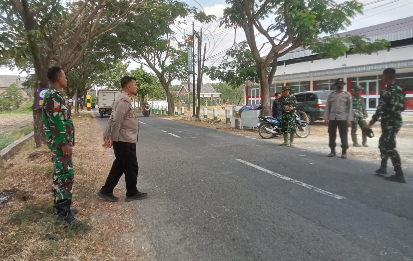 Personel Polsek Kedungadem turun langsung mengamankan proses pembongkaran bangunan lama yang akan disulap menjadi kawasan pujasera (rest area) lengkap dengan mushala dan toilet umum, Sabtu (18/7/2026).