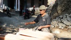 Salah satu wujud nyata partisipasi warga terlihat dari keterlibatan Madrohim (59), warga Dusun Kunir RT 01/RW 09, Desa Gumelem Kulon, Kecamatan Susukan, yang turut merakit papan bekisting untuk pembangunan plat beton, Selasa (21/07/2026).