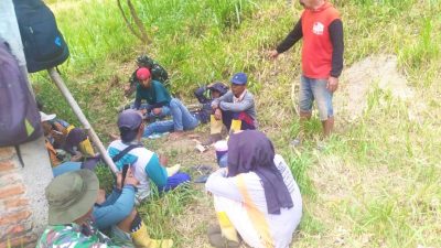 Suasana hangat tampak saat sejumlah prajurit TNI bersama warga memanfaatkan waktu istirahat dengan duduk lesehan di bawah rindangnya pepohonan di tepi jalan. Sambil menunggu kedatangan truk pengangkut material cor beton, mereka menikmati secangkir kopi dan berbincang santai tanpa sekat.