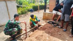 Salah satu tahapan penting yang dilakukan adalah pengukuran ketinggian pondasi menggunakan selang waterpass oleh Praka Agit bersama warga Bagio (51), Selasa (21/07/2026).