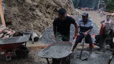 Didorong bergantian oleh Pelda Ratam bersama warga, angkong berisi adukan beton itu menjadi urat nadi pengecoran rabat beton sepanjang 737 meter, lebar 2,5 meter, dan tebal 0,15 meter di Dusun Kunir RT 01/09, Desa Gumelem Kulon, Kecamatan Susukan, Sabtu (25/07/2026).