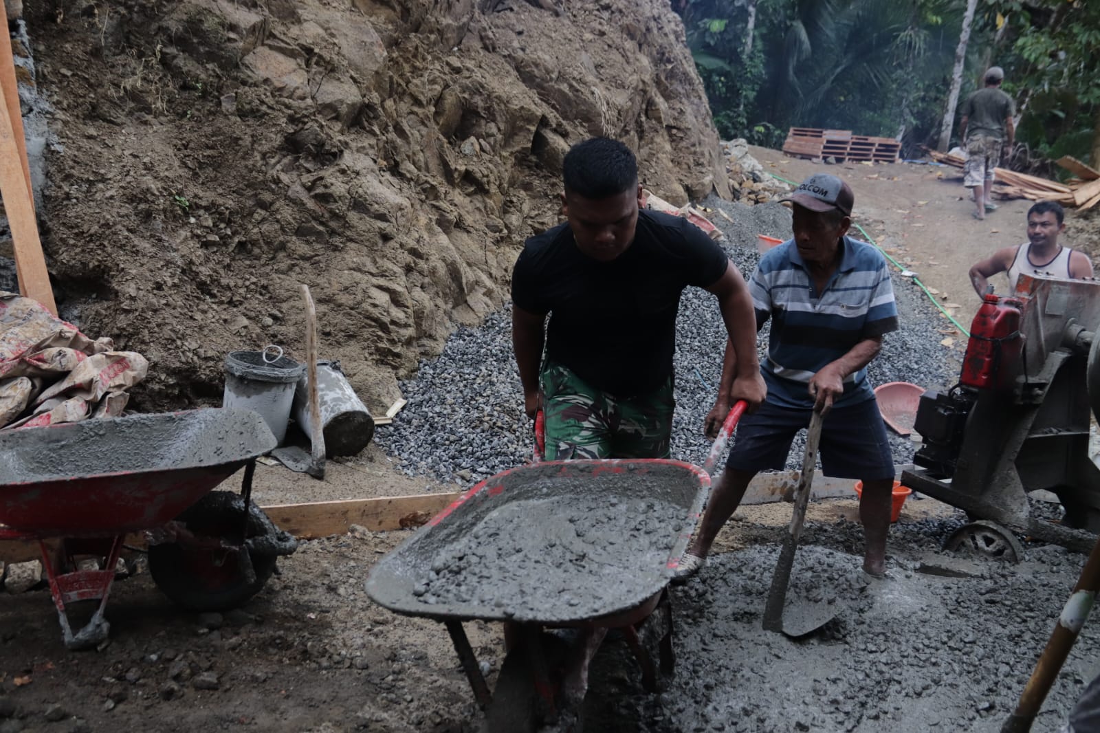 Didorong bergantian oleh Pelda Ratam bersama warga, angkong berisi adukan beton itu menjadi urat nadi pengecoran rabat beton sepanjang 737 meter, lebar 2,5 meter, dan tebal 0,15 meter di Dusun Kunir RT 01/09, Desa Gumelem Kulon, Kecamatan Susukan, Sabtu (25/07/2026).