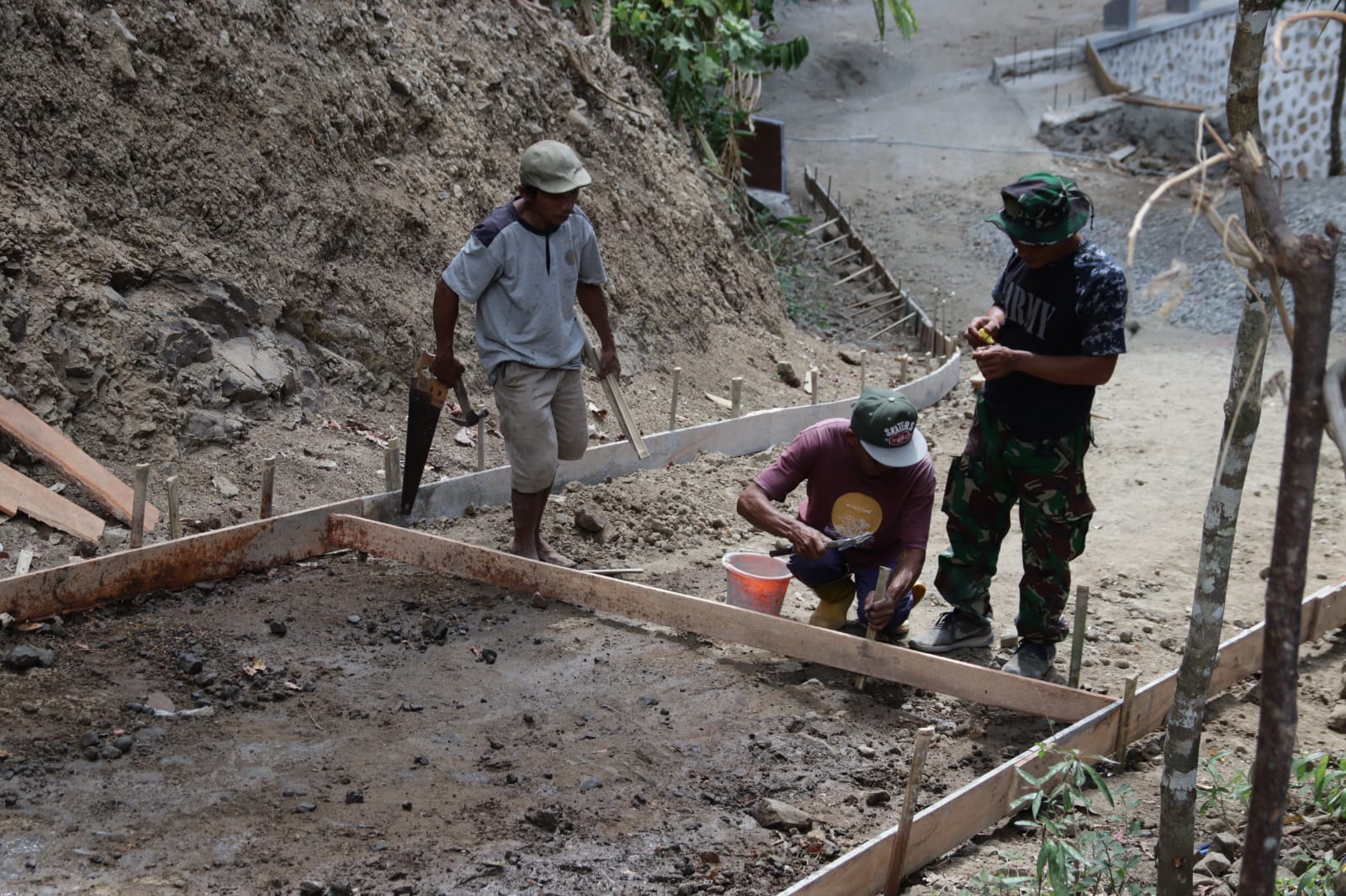 Tahapan pemasangan bekisting menjadi salah satu proses penting dalam pembangunan jalan rabat beton pada pelaksanaan TMMD Reguler ke-129 Tahun Anggaran 2026 Kodim 0704/Banjarnegara di Dusun Kunir RT 01 RW 09, Desa Gumelem Kulon, Kecamatan Susukan, Minggu (26/7/2026).