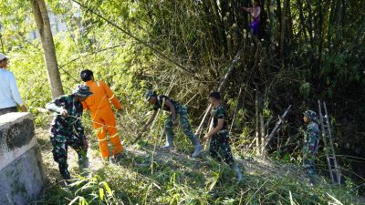 Melalui aksi gotong royong, personel Satgas TMMD bersama masyarakat melaksanakan kerja bakti membersihkan bantaran Sungai Kesongo di sekitar Jembatan Brang Etan, Desa Kesongo, Kecamatan Kedungadem, Minggu (26/7/2026).