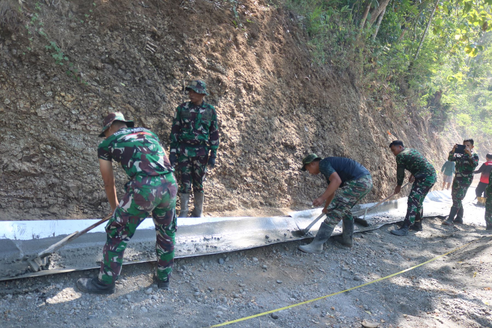 Kreativitas dan semangat gotong royong menjadi kunci percepatan pembangunan jalan rabat beton dalam Program TMMD Reguler ke-129 Tahun Anggaran 2026 Kodim 0704/Banjarnegara di Dusun Kunir RT 01/RW 09, Desa Gumelem Kulon, Kecamatan Susukan, Senin (20/7/2026).