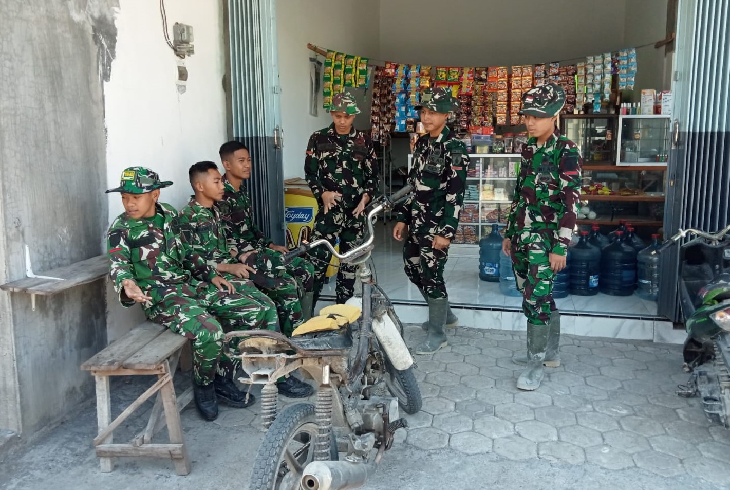 Anggota Satgas TMMD memanfaatkan waktu istirahat sore mereka dengan singgah di warung sembako milik Bu Yanti, Jumat (24/7/2026).