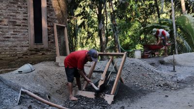 Di tengah pelaksanaan TMMD Reguler ke-129 Tahun Anggaran 2026 Kodim 0704/Banjarnegara, lelaki sepuh itu tampak tekun mengayak pasir di lokasi pembangunan rabat beton di Dusun Kunir RT 01 RW 09, Desa Gumelem Kulon, Kecamatan Susukan, Kabupaten Banjarnegara, Minggu (19/07/2026).