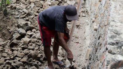 alah satu sosok yang menjadi perhatian adalah Sartono (56), warga setempat yang dengan keterampilan dan pengalamannya turut memperkuat pembangunan talud, Sabtu (18/7/2026).