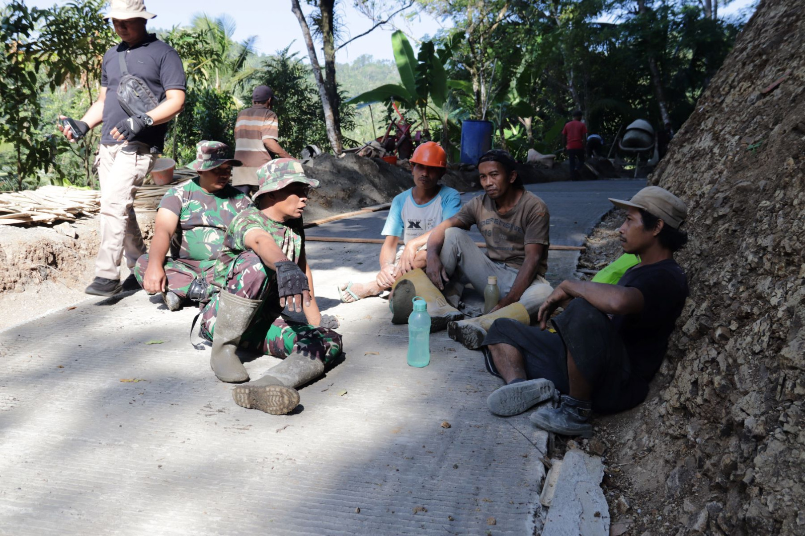 Kebersamaan itu tampak saat personel Satgas TMMD memanfaatkan waktu istirahat untuk bercengkerama dengan warga di lokasi pembangunan rabat beton, Dusun Kunir RT 01 RW 09, Desa Gumelem Kulon, Kecamatan Susukan, Rabu (22/7/2026).