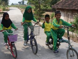 Dengan sepeda yang mereka kayuh penuh semangat, perjalanan menuju sekolah kini terasa lebih nyaman setelah akses jalan di wilayah mereka berubah menjadi lebih baik.