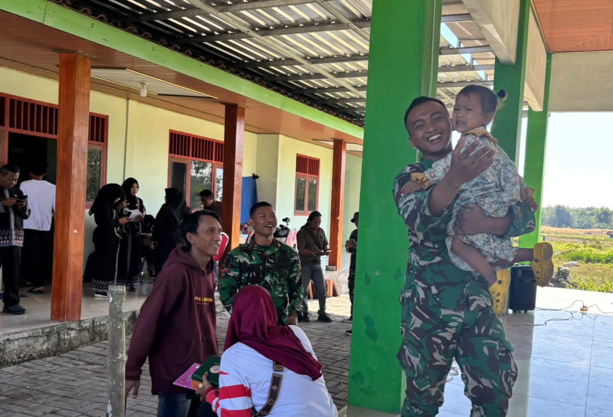 Di halaman Balai Desa Kesongo, seorang prajurit Satgas TMMD tampak menggendong seorang balita sambil bercanda. Tak lama kemudian, anak-anak lainnya ikut mendekat, tertawa, dan bermain bersama para anggota TNI. Suasana yang awalnya dipenuhi kegiatan resmi seketika berubah menjadi hangat dan penuh keceriaan.