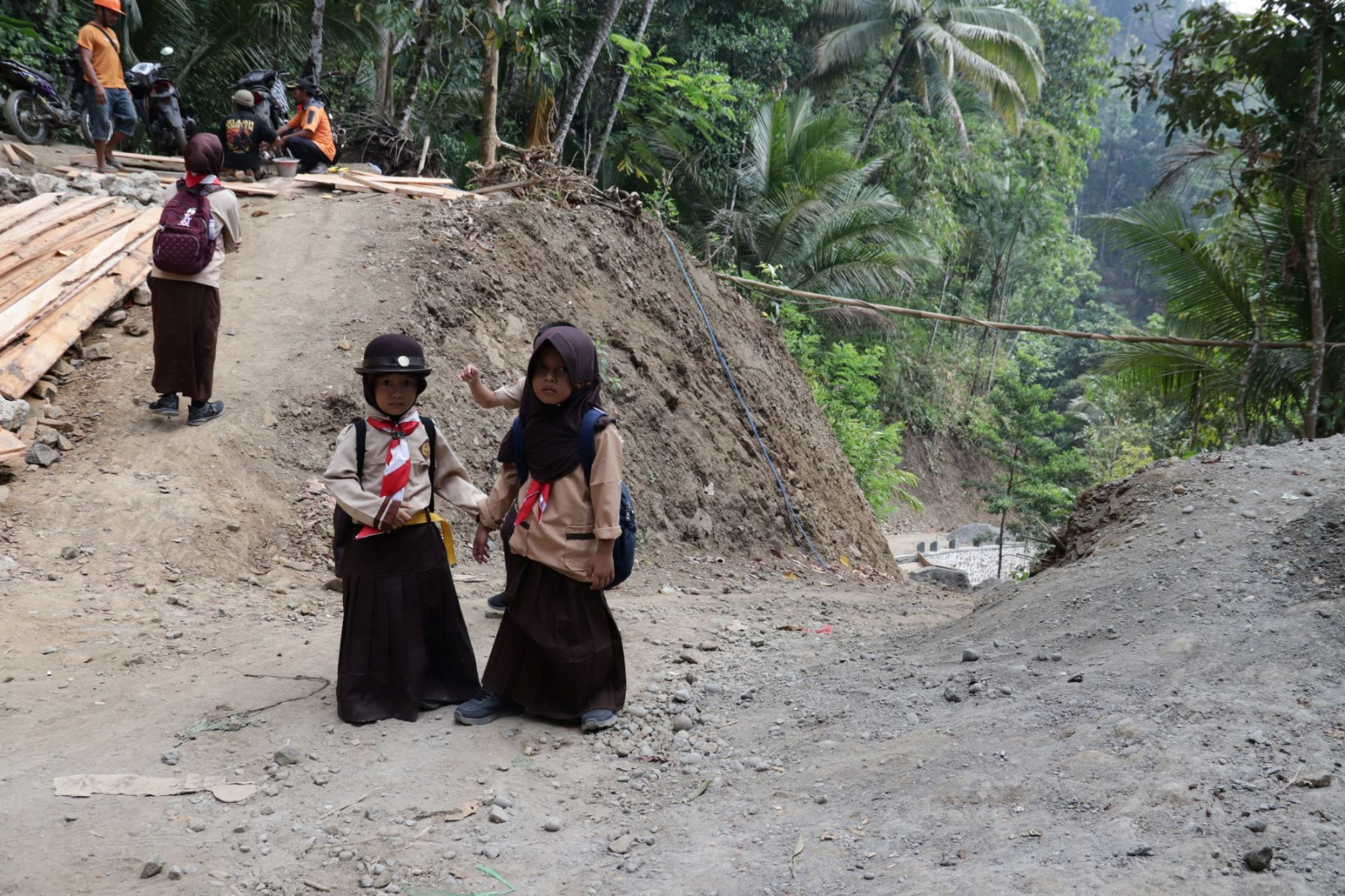 Di tengah aktivitas pengecoran jalan di Dusun Kunir RT 01 RW 09, Desa Gumelem Kulon, Kecamatan Susukan, dua siswi kelas 1 SD, Kalisa dan Arumi, datang mengenakan seragam Pramuka untuk menyaksikan langsung semangat gotong royong antara prajurit TNI dan masyarakat, Minggu (19/7/2026).