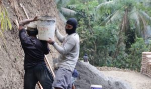 sosok Sanudin terlihat sigap melangsir pasir untuk mendukung proses pembangunan rabat beton sepanjang 737 meter dengan lebar 2,5 meter dan ketebalan 15 sentimeter, Jumat (31/7/2026).