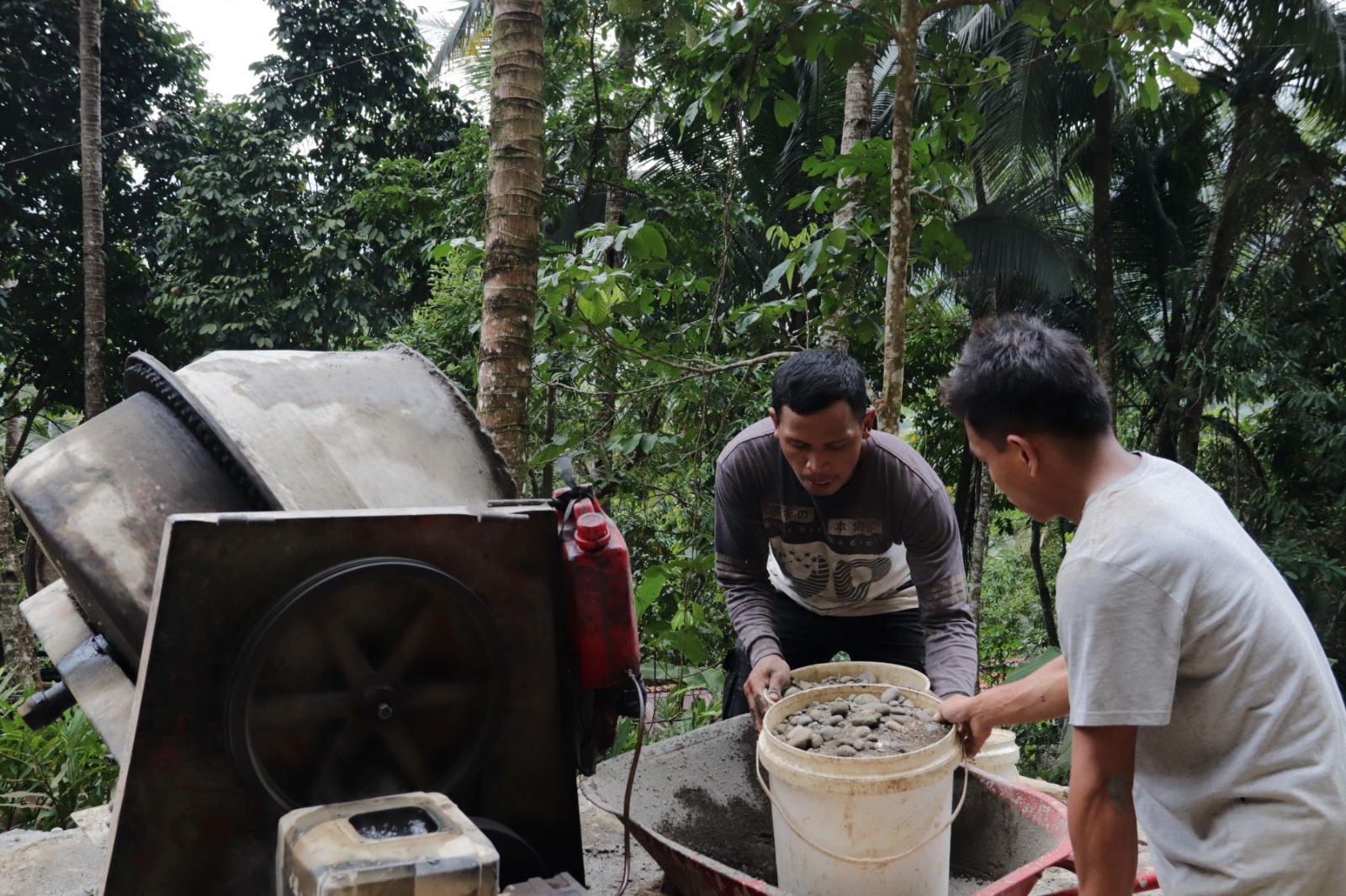 Di balik putaran mesin tersebut, Hamid (30), warga setempat, mengemban peran penting sebagai operator molen yang memastikan pasokan adukan beton tetap tersedia untuk mendukung kelancaran pembangunan.