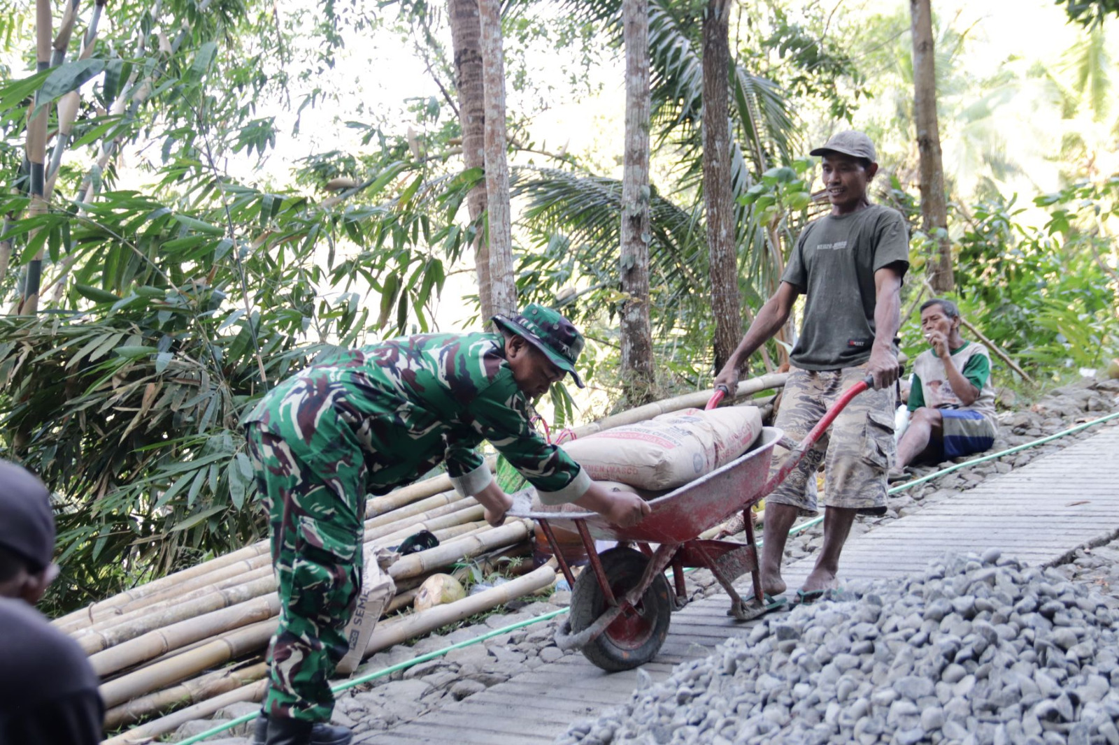 Di balik putaran mesin yang menjadi denyut pembangunan itu, tampak sosok Pratu Farhan, prajurit Yonif 405/Suryakusuma yang tergabung dalam Satgas TMMD Reguler ke-129 Kodim 0704/Banjarnegara, bekerja tanpa henti memastikan setiap adukan beton memiliki kualitas terbaik, Minggu (19/07/2026).