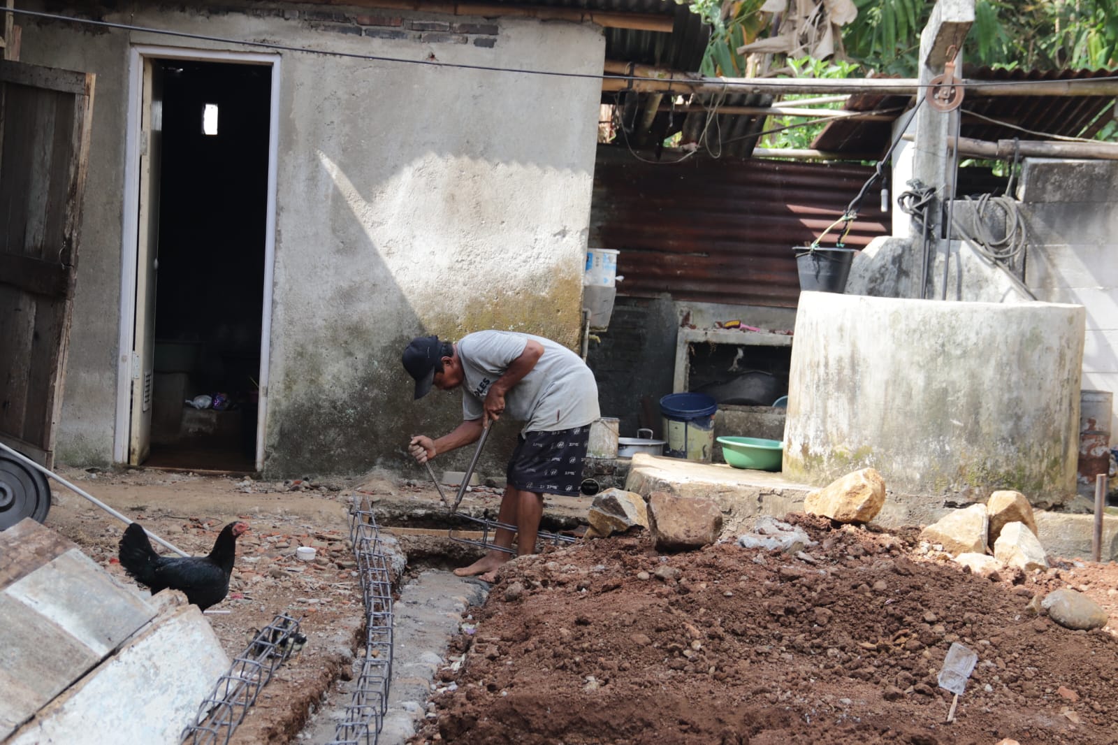 Deretan besi ring mulai tersusun rapi di atas dinding rumah yang tengah dibangun. Dengan gerakan yang penuh ketelitian, Risanto (74) tampak sibuk memasang besi ring untuk Rumah Tidak Layak Huni (RTLH) milik Pak Toid di Dusun Kunir RT 01/09, Desa Gumelem Kulon, Kecamatan Susukan, Kabupaten Banjarnegara.