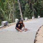 ketika Saeful bersama anggota Satgas TMMD melakukan proses finishing pada pengecoran rabat beton di Dusun Kunir RT 01/09, Desa Gumelem Kulon, Kecamatan Susukan, Rabu (5/8/2026).