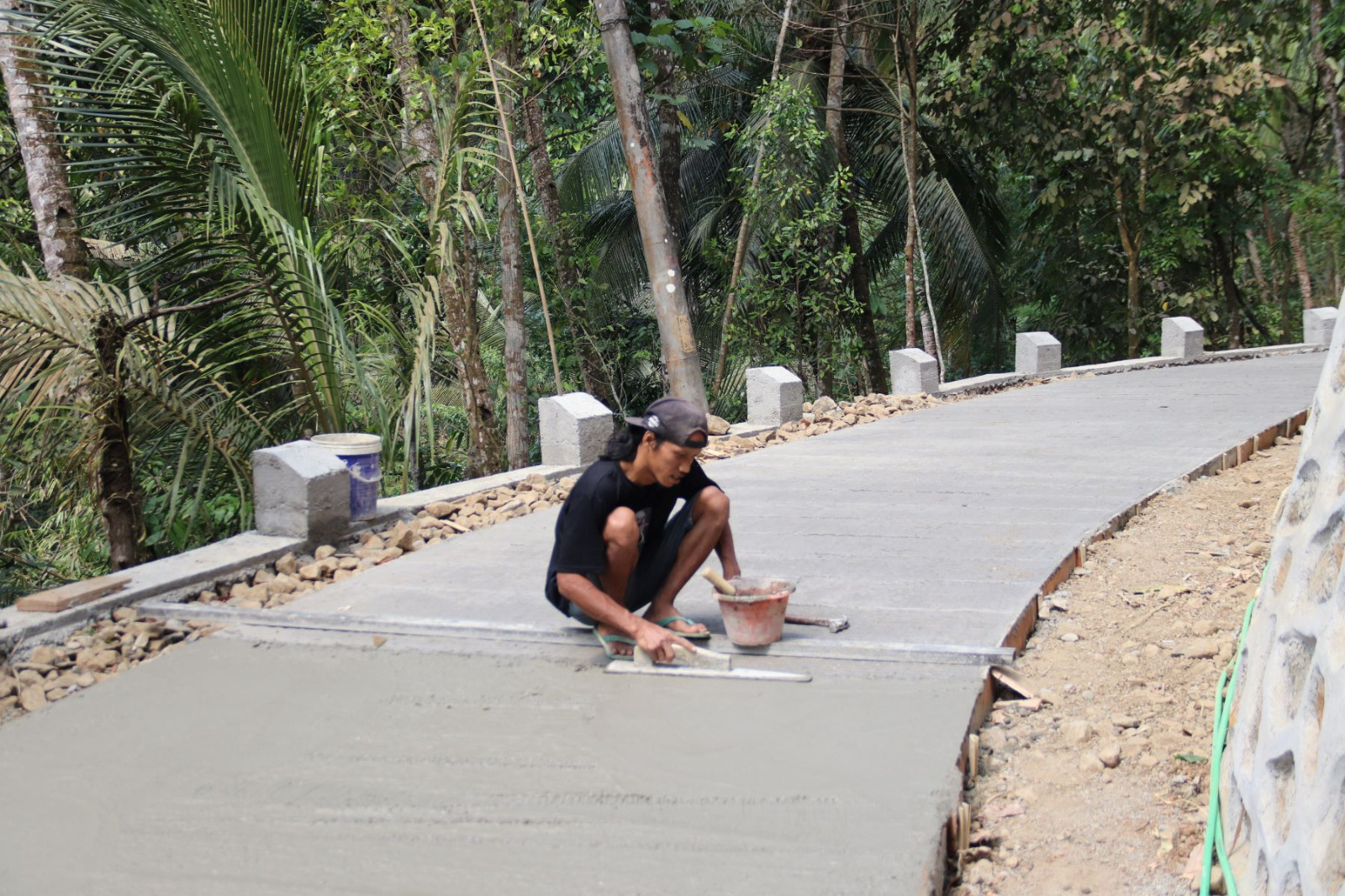 ketika Saeful bersama anggota Satgas TMMD melakukan proses finishing pada pengecoran rabat beton di Dusun Kunir RT 01/09, Desa Gumelem Kulon, Kecamatan Susukan, Rabu (5/8/2026).
