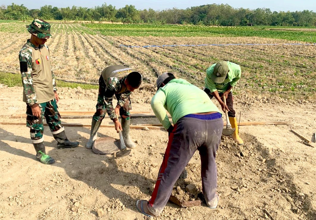 Satgas TMMD ke-129 Kodim 0813 Bojonegoro bersama warga bergotong royong membangun pondasi lapak PKL di kawasan rest area Desa Kesongo, Kecamatan Kedungadem, Kabupaten Bojonegoro.