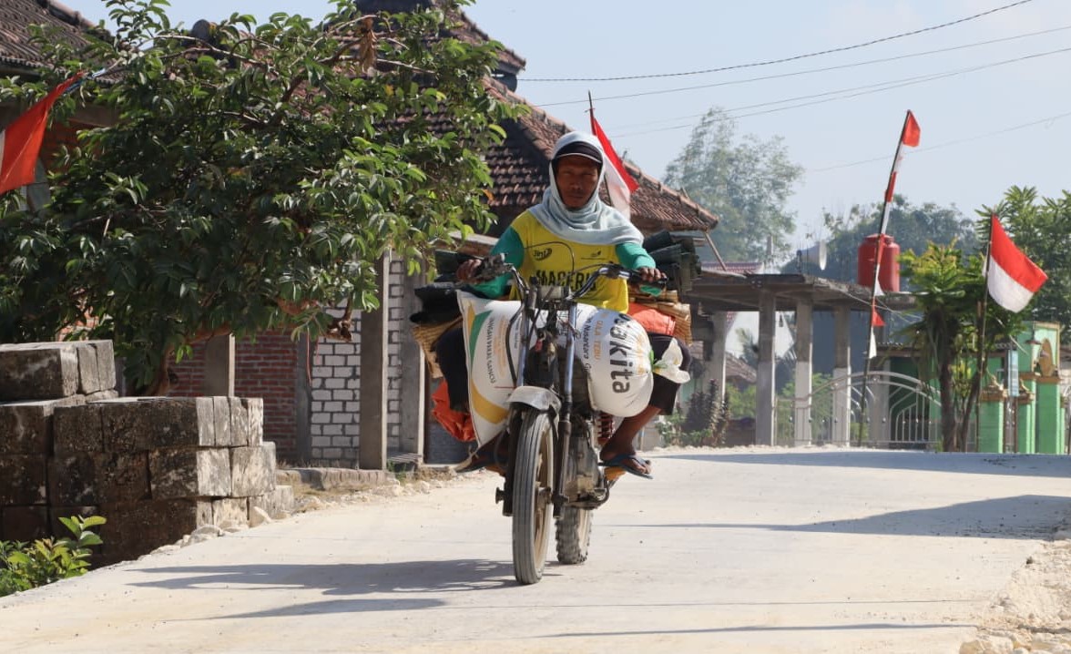 Foto: Seorang warga melintas di atas jalan cor beton hasil pembangunan TMMD ke-129 Kodim 0813/Bojonegoro di Dusun Kedungpandan, Desa Kesongo, Kecamatan Kedungadem, Rabu (5/8/2026). Infrastruktur baru ini mempermudah akses masyarakat sekaligus mendukung aktivitas ekonomi, pendidikan, dan pelayanan kesehatan. Foto: Deni Aripandi/Sumber TMMD Bojonegoro.