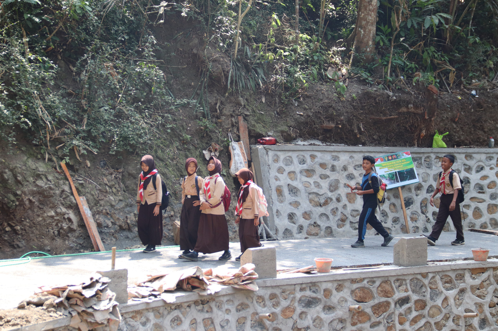 Jalan Baru untuk Generasi Muda: Naila, siswi SD Negeri 6 Gumelem Kulon, melintas di ruas rabat beton yang dibangun melalui program TMMD Reguler ke-129 Kodim 0704/Banjarnegara di Dusun Kunir, Desa Gumelem Kulon, Kecamatan Susukan, Jumat (7/8/2026). Jalan baru tersebut memberikan akses yang lebih aman dan nyaman bagi warga, termasuk para pelajar.