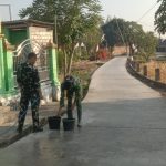 Personel Satgas TNI Manunggal Membangun Desa (TMMD) ke-129 Kodim 0813/Bojonegoro bersama warga melaksanakan perawatan jalan beton yang telah selesai dicor di Dusun Kedungpandan, Desa Kesongo, Kecamatan Kedungadem, Kabupaten Bojonegoro, Minggu (2/8/2026).