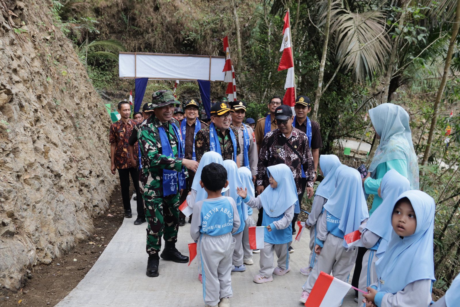 Keterangan Foto: Anak-anak PAUD Desa Gumelem Kulon menyambut Dandim 0704/Banjarnegara Letkol Inf Nodelismen Hulu, S.Pd., dan rombongan dalam rangkaian penutupan TMMD Reguler ke-129 Tahun Anggaran 2026 di Desa Gumelem Kulon, Kecamatan Susukan, Kabupaten Banjarnegara, Kamis (13/8/2026). Foto: Pendim Banjarnegara.