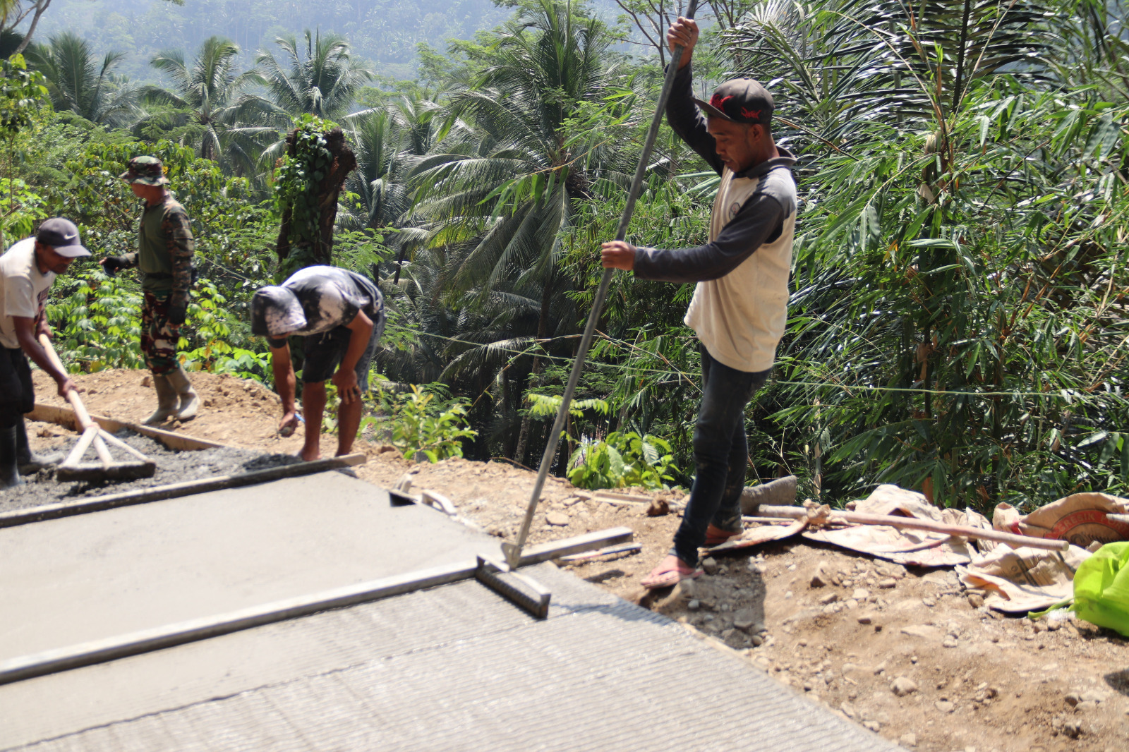 Finishing Jalan TMMD: Samsi melakukan grooving pada permukaan rabat beton dalam pelaksanaan TMMD Reguler ke-129 Kodim 0704/Banjarnegara di Dusun Kunir RT 01/09, Desa Gumelem Kulon, Kecamatan Susukan, Jumat (7/8/2026). Pembuatan alur pada beton dilakukan untuk meningkatkan daya cengkeram permukaan jalan.