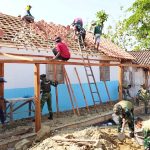 Babinsa Desa Kesongo Serka Lasmidi bersama anggota Satgas TMMD ke-129 Kodim 0813 Bojonegoro dan warga bergotong royong memasang genting pada rumah penerima program RTLH di Desa Kesongo, Kecamatan Kedungadem, Kabupaten Bojonegoro, Minggu (09/08/2026). Foto: Deni Aripandi/Sumber TMMD Bojonegoro.