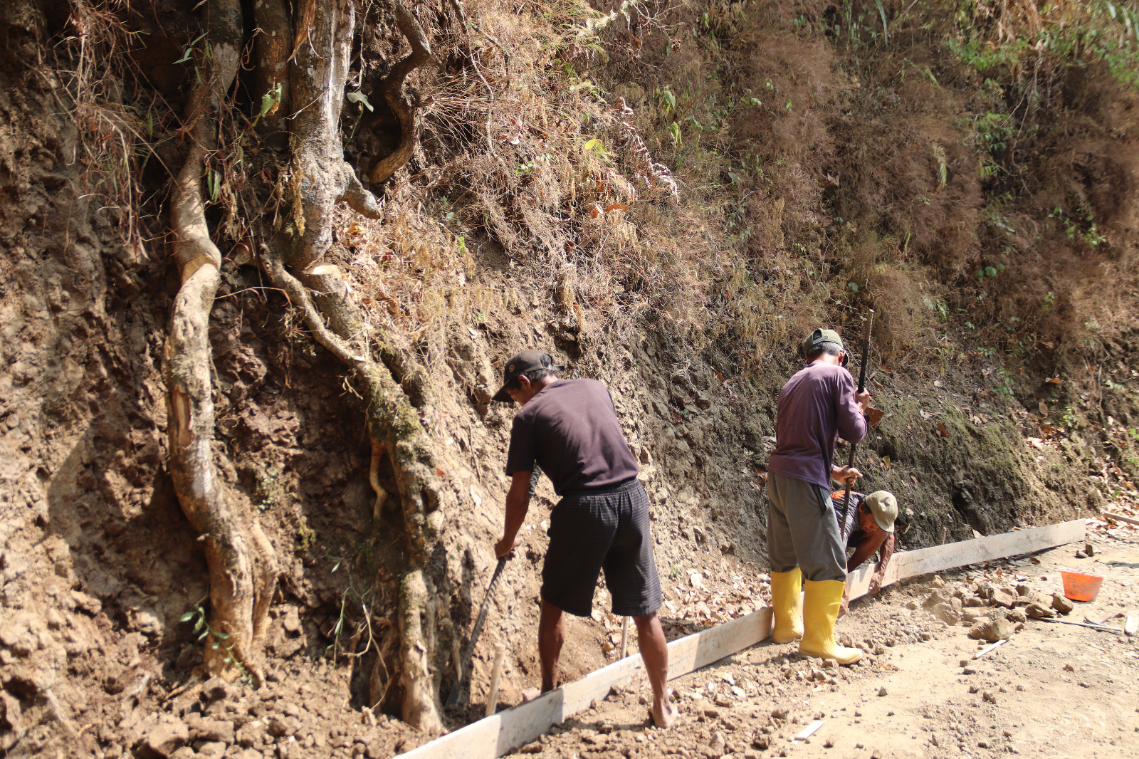 Pak Madrohim bersama warga memperkuat dan memeriksa bekisting rabat beton agar tetap kokoh selama proses pengecoran TMMD Reguler ke-129 di Desa Gumelem Kulon, Kecamatan Susukan, Banjarnegara.