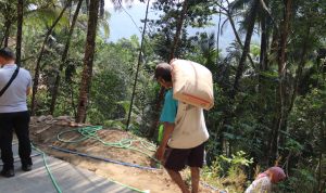 Pak Narto melangsir karung semen untuk mendukung proses pengecoran rabat beton TMMD Reguler ke-129 di Dusun Kunir RT 01/09, Desa Gumelem Kulon, Kecamatan Susukan, Kabupaten Banjarnegara, Senin (10/08/2026). Foto: Deni Aripandi/Sumber TMMD Banjarnegara.