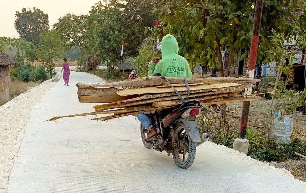 Warga melintas di jalan cor beton hasil pembangunan program TMMD ke-129 Kodim 0813/Bojonegoro di Dusun Mundu, Desa Kesongo, Kecamatan Kedungadem, Kabupaten Bojonegoro, Selasa (11/8/2026). Foto: Deni Flamboyan/Sumber TMMD Bojonegoro