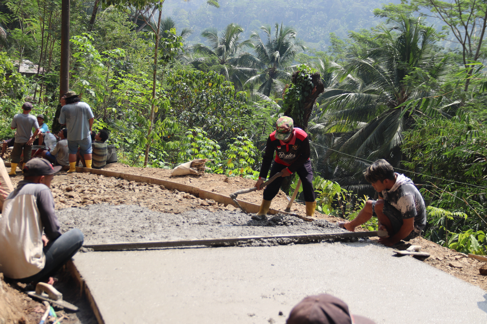 Ketua RW 09 Pak Sakum bersama anggota Satgas TMMD Reguler ke-129 Kodim 0704/Banjarnegara dan warga bergotong royong dalam proses pengecoran rabat beton di Dusun Kunir RT 01/09, Desa Gumelem Kulon, Kecamatan Susukan, Kamis (6/8/2026). Semangat kebersamaan menjadi bukti kuatnya sinergi TNI dan masyarakat dalam menyukseskan pembangunan desa. Foto: Deni Aripandi/Sumber TMMD Banjarnegara