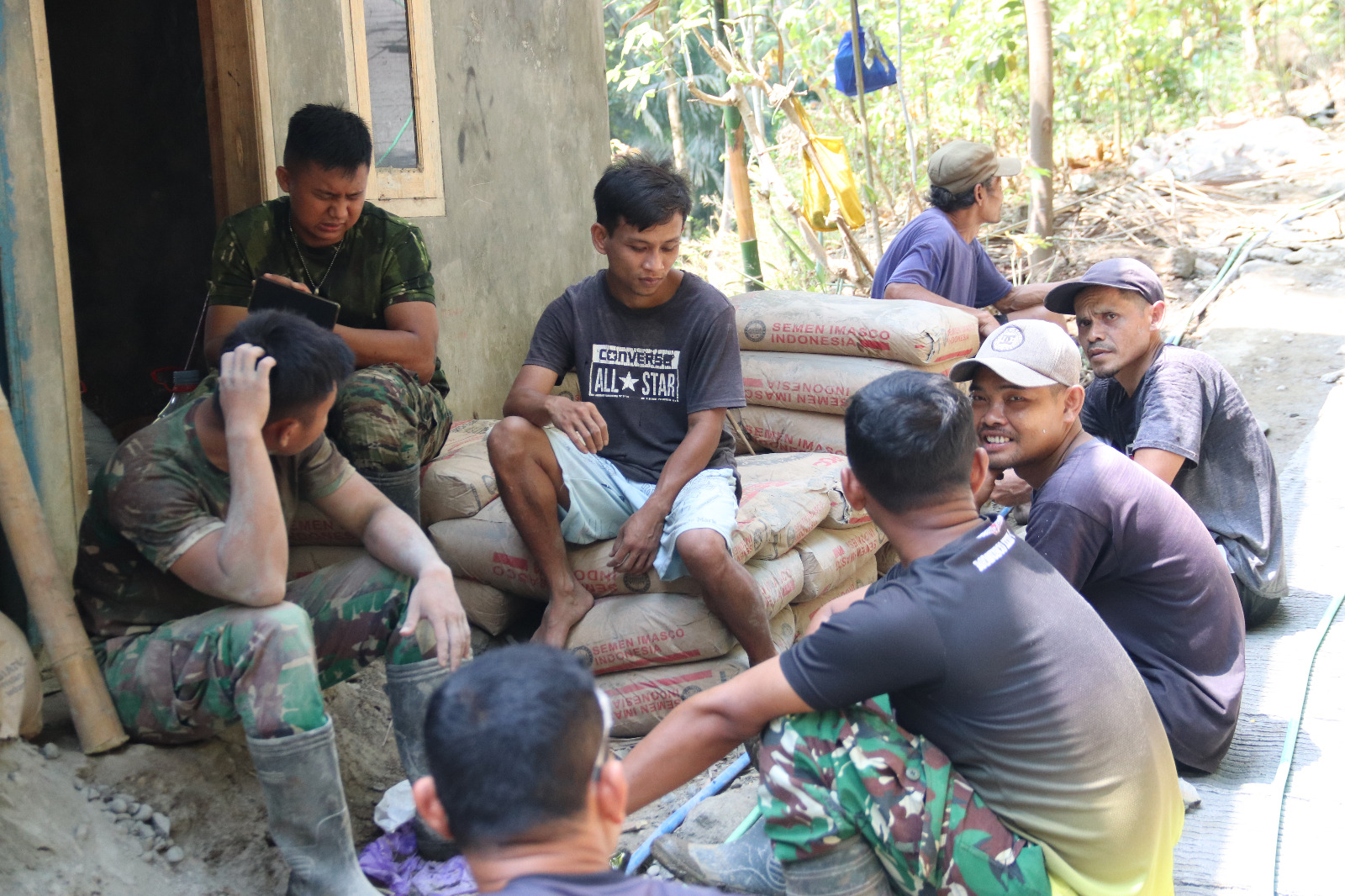 Anggota Satgas TMMD Reguler ke-129 Kodim 0704/Banjarnegara menikmati waktu istirahat sambil berbincang dan bercanda di sela-sela pengerjaan pembangunan rabat beton di Desa Gumelem Kulon, Kecamatan Susukan, Banjarnegara.