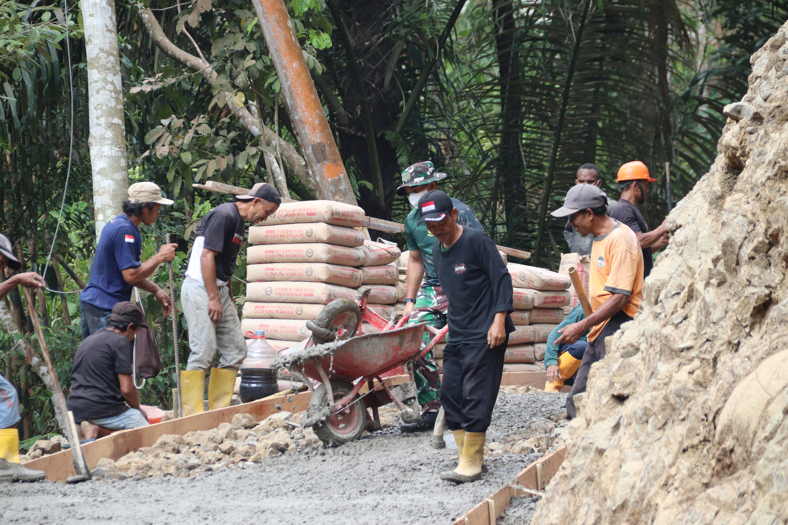 Di tengah proses pembangunan rabat beton di Dusun Kunir RT 01/09, Desa Gumelem Kulon, Kecamatan Susukan, Kabupaten Banjarnegara, Pratu Agung menunjukkan dedikasi tinggi dengan terus mengangkut adukan beton menggunakan angkong untuk memperlancar pekerjaan, Sabtu (1/8/2026).