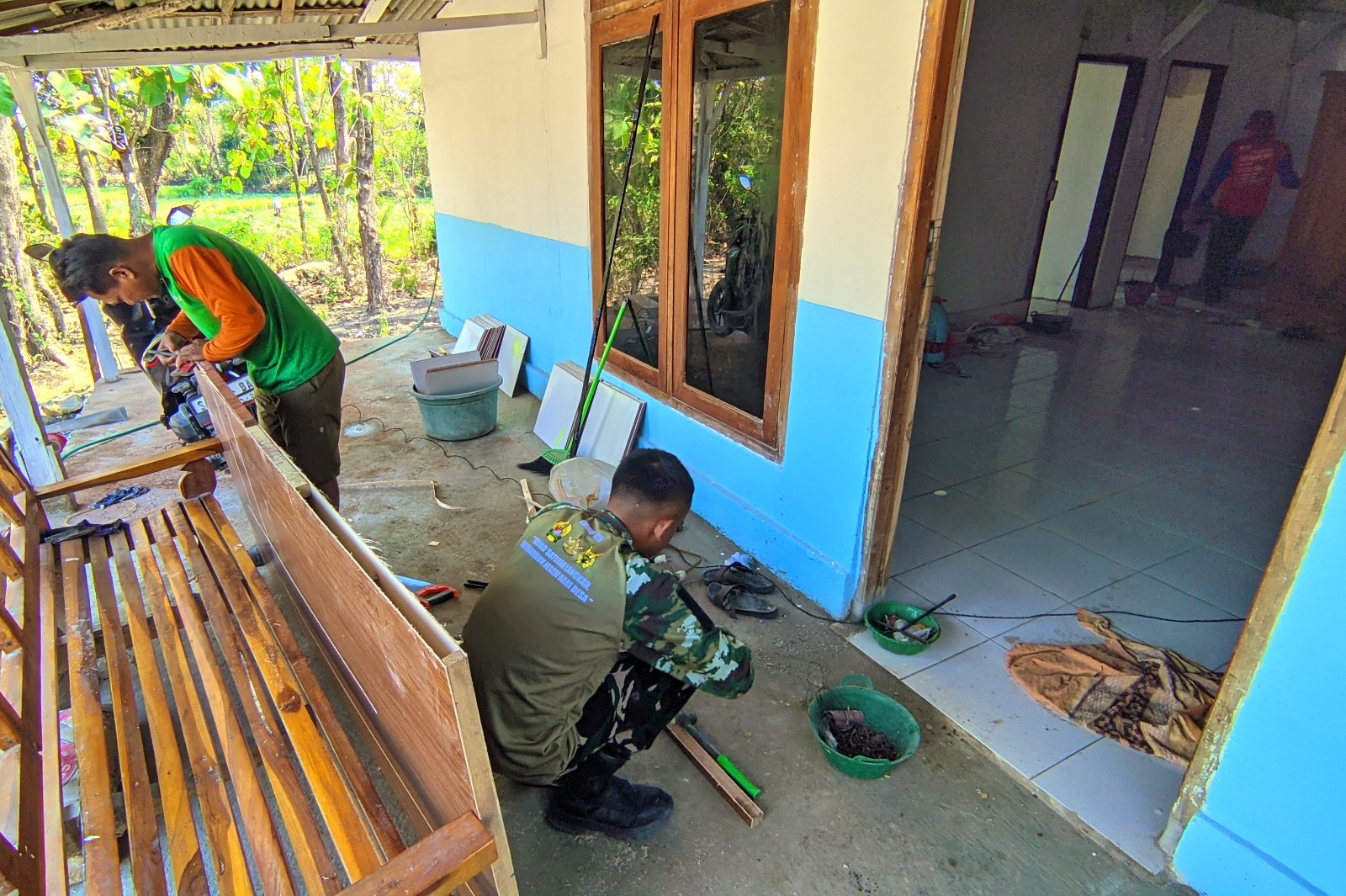 Personel Satgas TMMD ke-129 Kodim 0813 Bojonegoro bersama warga bergotong royong mengerjakan rehabilitasi RTLH milik Jasmiati di Desa Kesongo, Kecamatan Kedungadem, Bojonegoro.