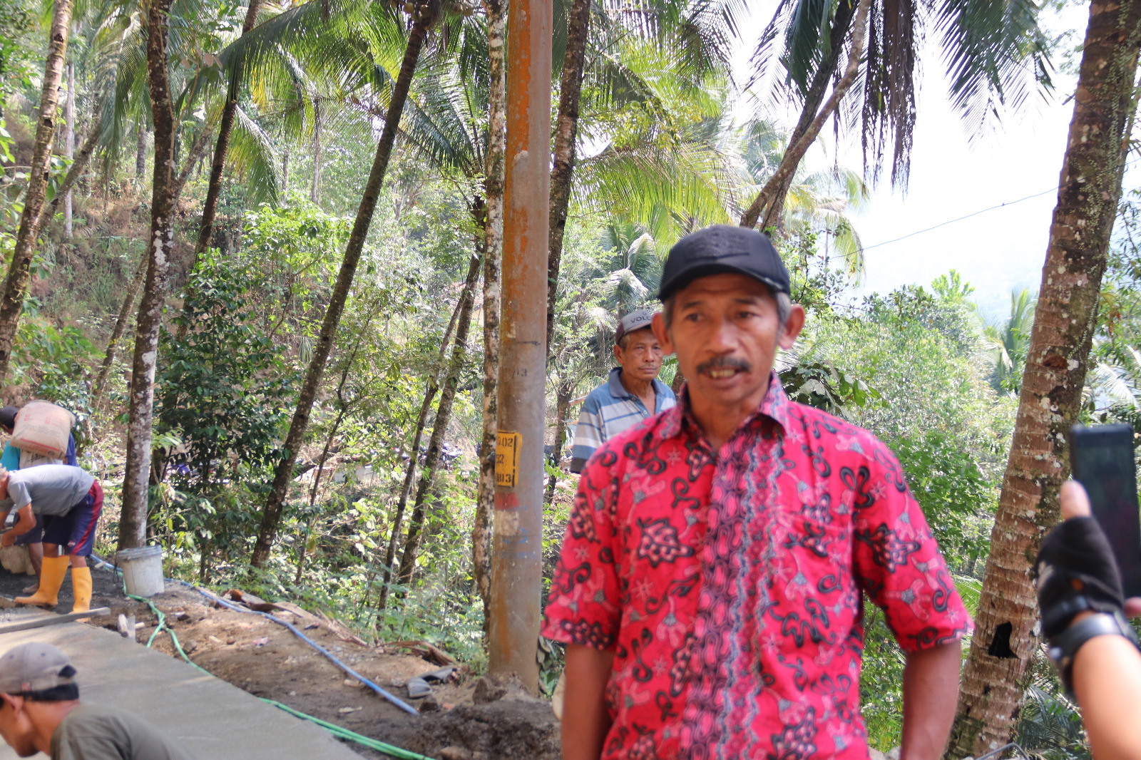 Pj Kepala Dusun Kunir, Pak Waryo, menyaksikan proses pembangunan rabat beton bersama anggota Satgas TMMD dan masyarakat di Desa Gumelem Kulon, Kecamatan Susukan, Banjarnegara.