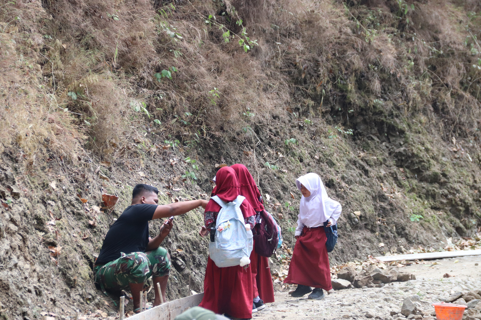 Dua siswi kembar SDN Gumelem Kulon, Naila dan Nabila, bersalaman dengan anggota Satgas TMMD Reguler ke-129 di sela pengerjaan rabat beton di Desa Gumelem Kulon, Kecamatan Susukan, Kabupaten Banjarnegara, Senin (10/08/2026). Foto: Deni Aripandi/Sumber TMMD Banjarnegara.