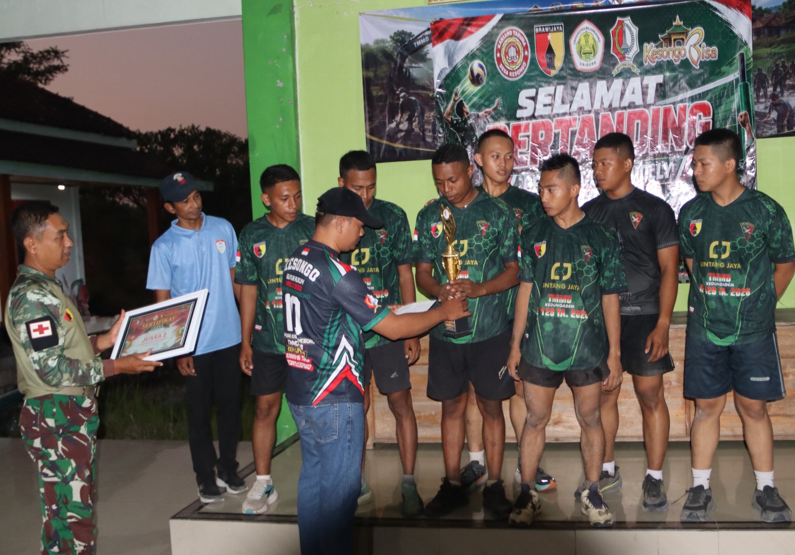 Jajaran Satgas TMMD ke-129 Kodim 0813 Bojonegoro bersama Pemerintah Desa Kesongo menyerahkan piala dan penghargaan kepada para pemenang Turnamen Bola Voli TMMD ke-129 di Desa Kesongo, Kecamatan Kedungadem, Kabupaten Bojonegoro, Sabtu (08/08/2026) malam. Foto: Deni Aripandi/Sumber TMMD Bojonegoro.