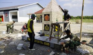 Personel Satgas TMMD ke-129 Kodim 0813/Bojonegoro bersama masyarakat saat mengerjakan pembangunan Tugu TMMD di kawasan Rest Area Terpadu Desa Kesongo, Kecamatan Kedungadem, Kabupaten Bojonegoro, Senin (10/8/2026). Foto: Deni Flamboyan/Sumber TMMD Bojonegoro